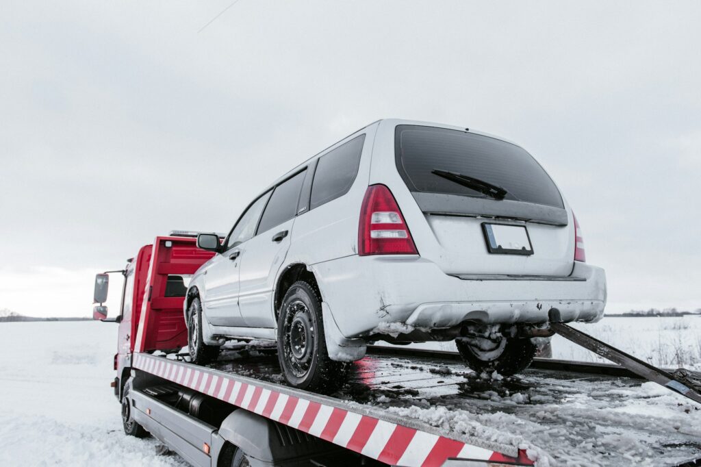 Car on tow truck on snow road